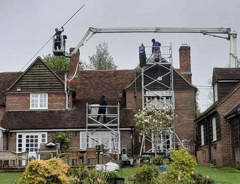 The Roof Moss Cleaners using cherry picker and scaffolding to clean roof safely and professionally in Rushden, Northamptonshire
